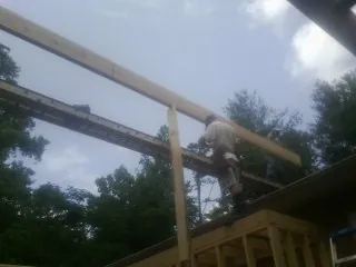 Carpenter setting a ridge beam over a new addition frame — Ice Dam Removal by Roofing Brothers in Martensdale